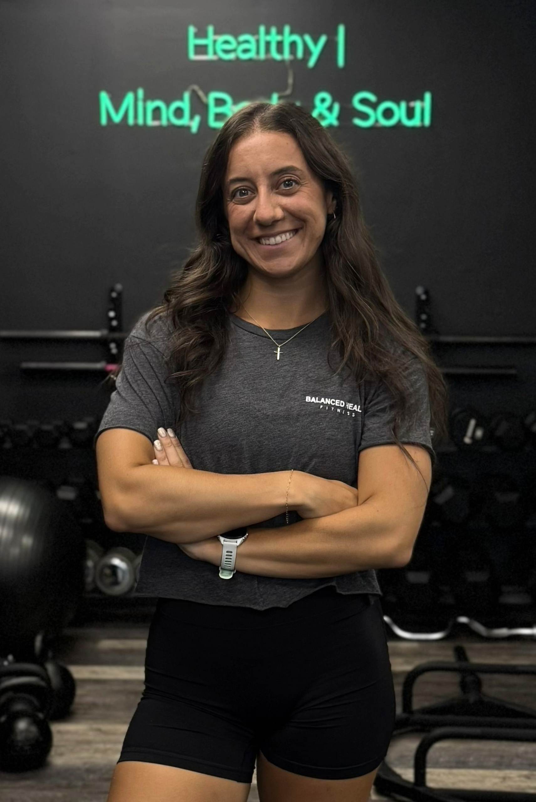 Maria Porcasi, coach at Balanced Health Fitness, in front of the Healthy Mind, Body and Soul sign in Seaford, NY.